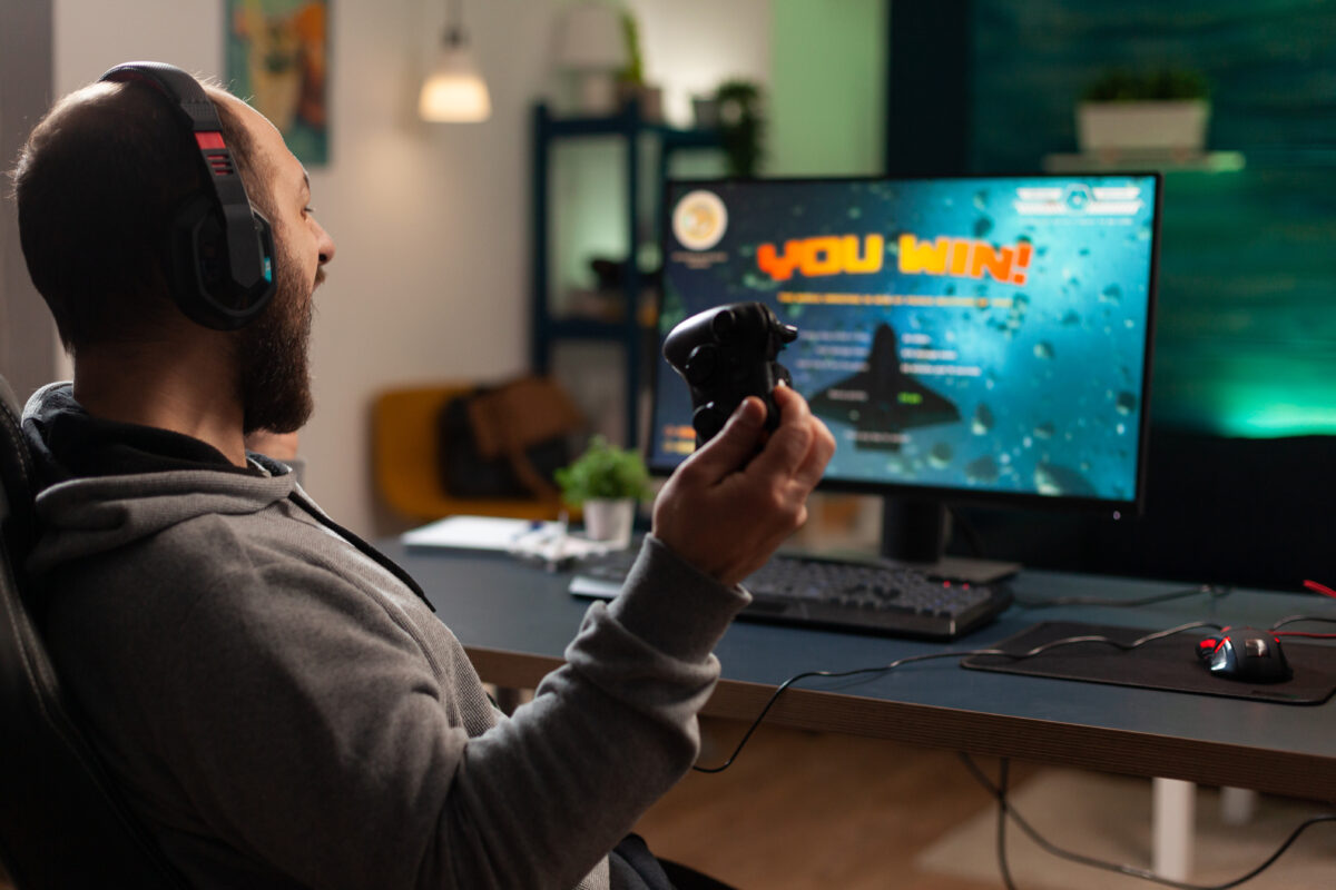 Player winning video games with controller and headset