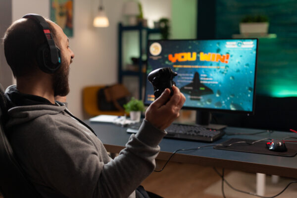 Player winning video games with controller and headset